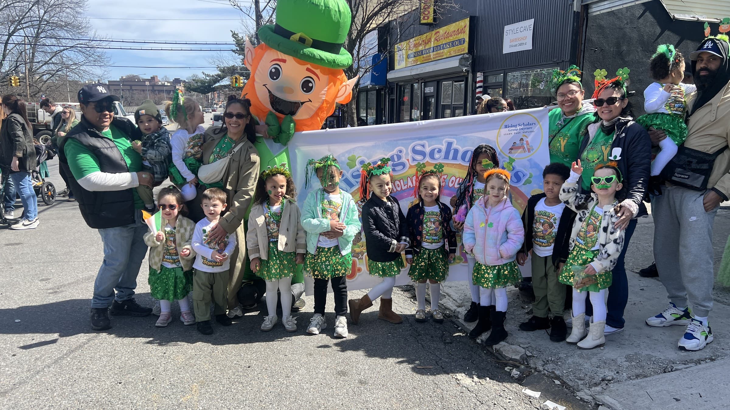 Rising Scholars children, families, and educators together at a Woodlawn St. Patrick’s Day neighborhood parade with the Rising Scholars banner