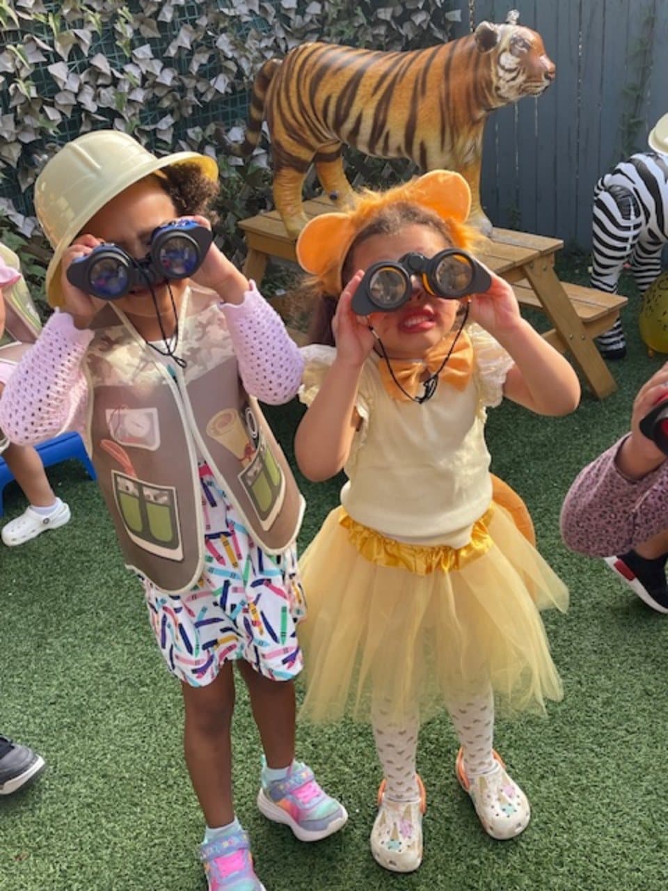 Two children exploring outdoors with binoculars during imaginative play