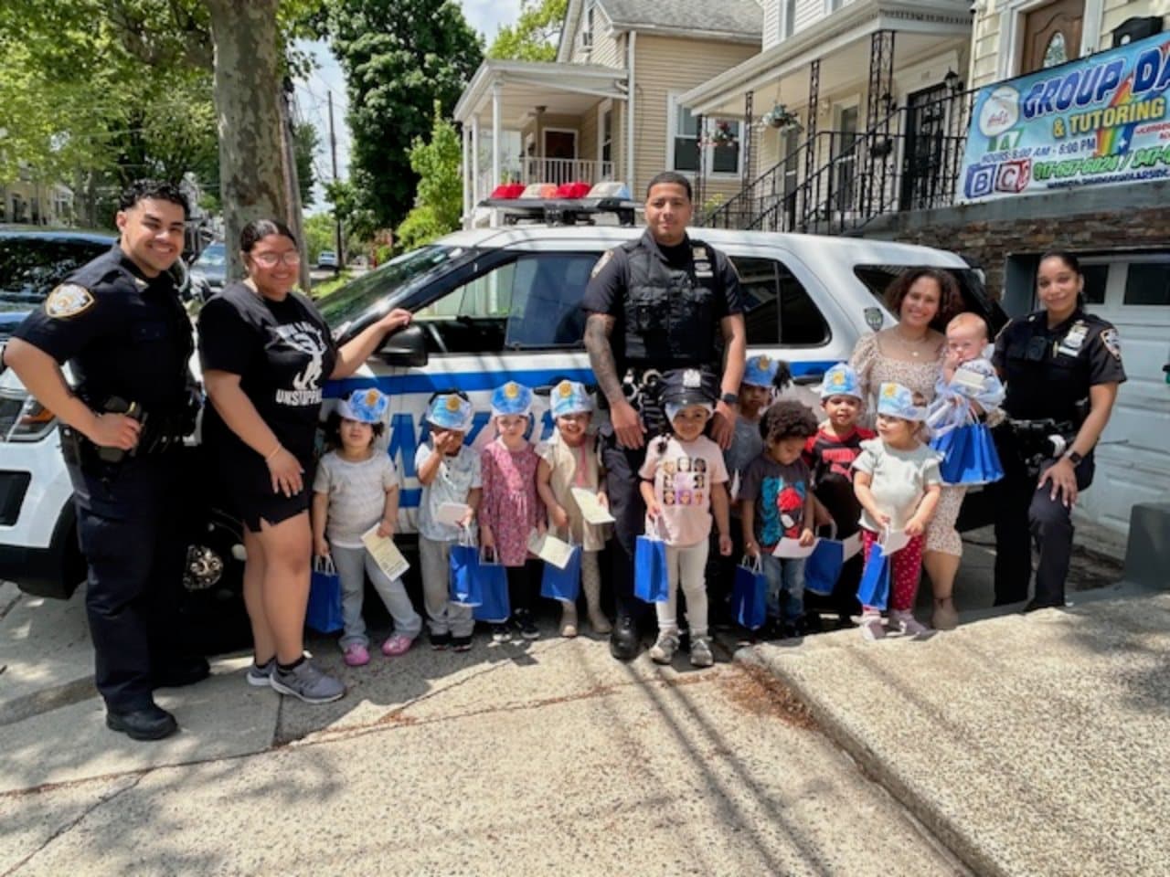 Rising Scholars children and teachers with NYPD officers during a community learning event